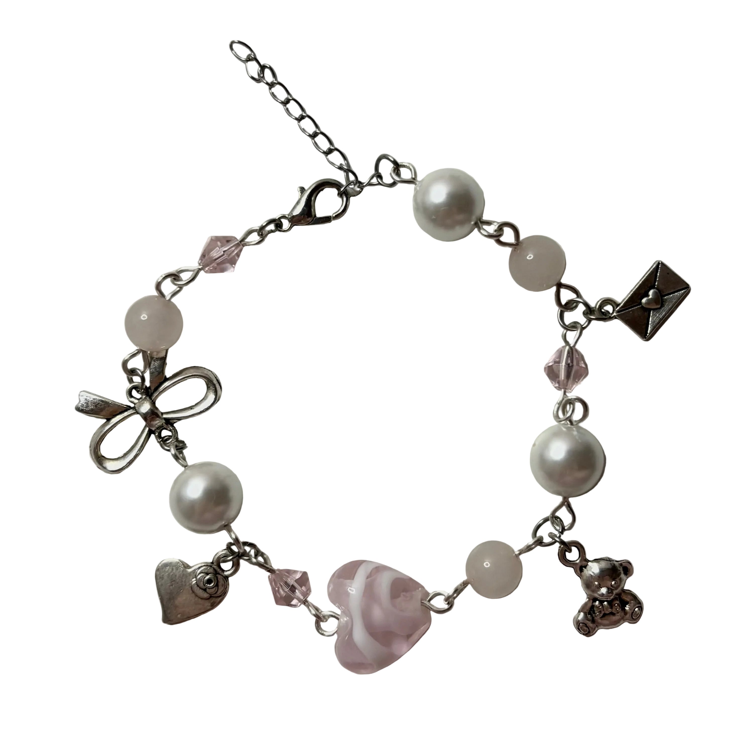 Bracelet with various charms including pearls, a bow, heart, and teddy bear on a light background